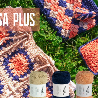 Três bolsas de crochê coloridas e novelos de lã sobre relva verde