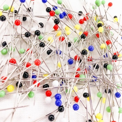 Alfinetes coloridos de cabeça redonda sobre fundo branco