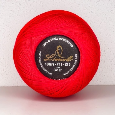 Rolo de linha de algodão mercerizado vermelho da marca Lincol em superfície branca