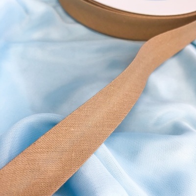 Fita bege em tecido sobre tecido azul claro brilhante