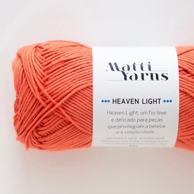 Novelo de fio coral com etiqueta branca com texto Matti Yarns Heaven Light