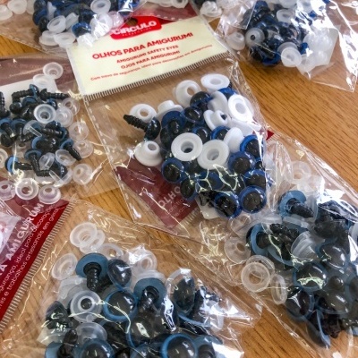 Pacotes de olhos de segurança para amigurumi em várias cores sobre madeira