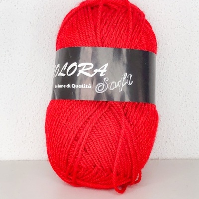 Novelo de fio vermelho com etiqueta preta numa superfície branca