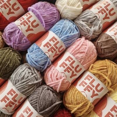 Várias bolas de lã coloridas com etiquetas 'FLUFFY'