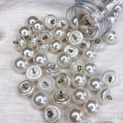 Botões de pressão pérola com metal em recipiente plástico e tecido branco