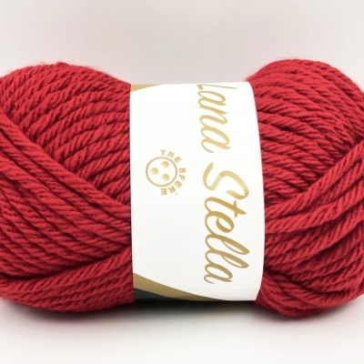 Novelo de lã vermelha com etiqueta branca e texto dourado