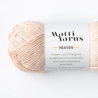 Novelo de fio de lã cor creme claro da marca Matti Yarns com etiqueta branca