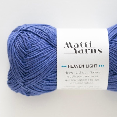 Novelo de fio azul Matti Yarns Heaven Light com etiqueta branca em fundo branco