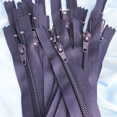 Vários fechos éclair pretos sobre tecido branco