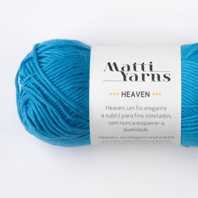 Novelo de lã azul turquesa Matti Yarns Heaven com etiqueta em fundo branco