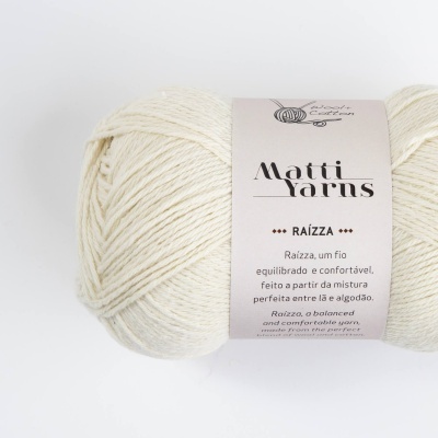 Novelo de fio bege claro com etiqueta da marca Matti Yarns e texto sobre o produto