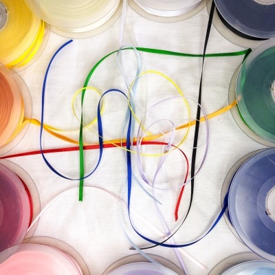 Rolos coloridos de fita decorativa em círculo com fitas desenroladas no centro