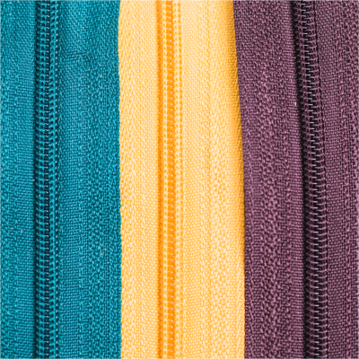 Três fechos éclair verticais em azul turquesa, amarelo e roxo sobre fundo branco