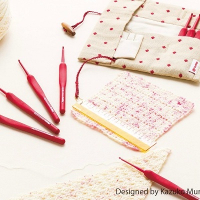 Conjunto de agulhas de crochet vermelhas e bolsa de tecido com padrão de pontos vermelhos