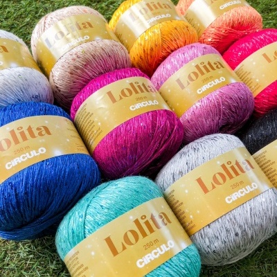 Novelos coloridos de lã Lolita Círculo com lantejoulas sobre relva