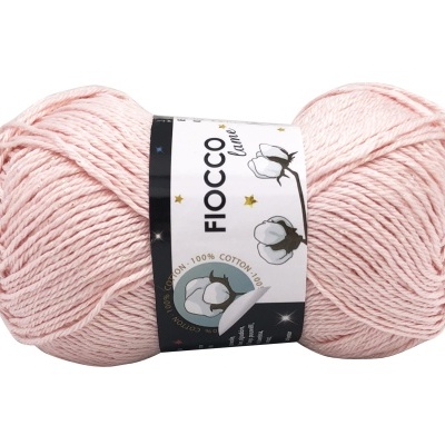 Novelo de lã cor-de-rosa claro com rótulo branco e desenhos de algodão