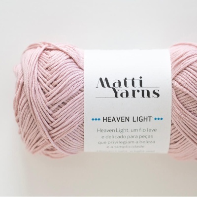 Novelo de fio rosa claro com etiqueta 'Matti Yarns HEAVEN LIGHT' em fundo branco