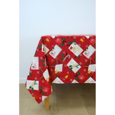 Toalha de mesa vermelha com estampado de Natal sobre mesa de madeira