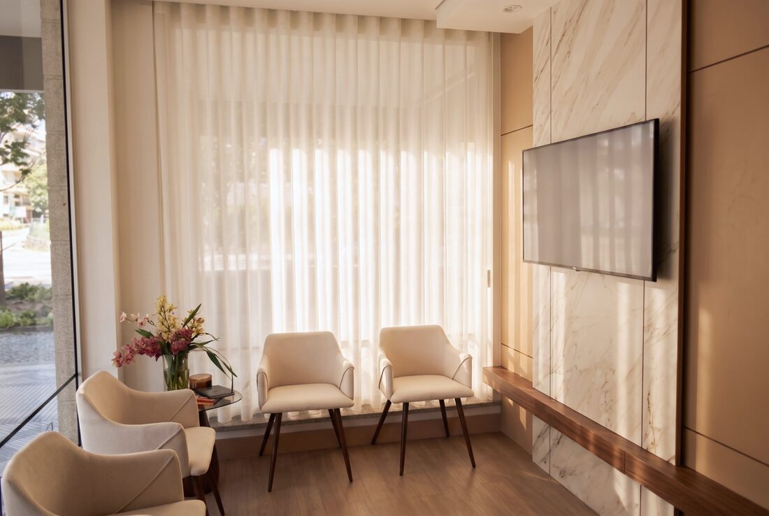 Sala de espera da Riarte Clinic, com cadeirões creme e luz natural