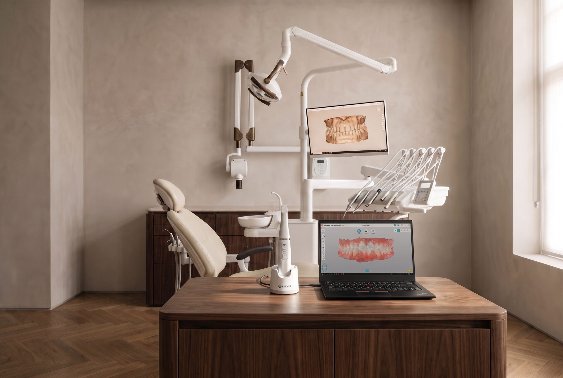 Scanner intraoral pousado na secretária do gabinete dentário, com o modelo tridimensional dos dentes no ecrã do portátil