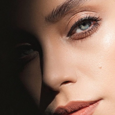 Close-up de rosto feminino com maquilhagem natural e batom vermelho suave
