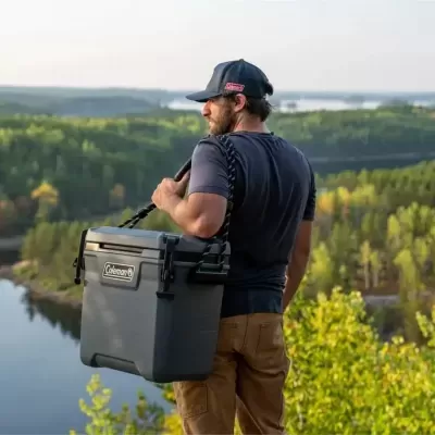 Homem a segurar cooler Coleman cinza escuro ao ar livre