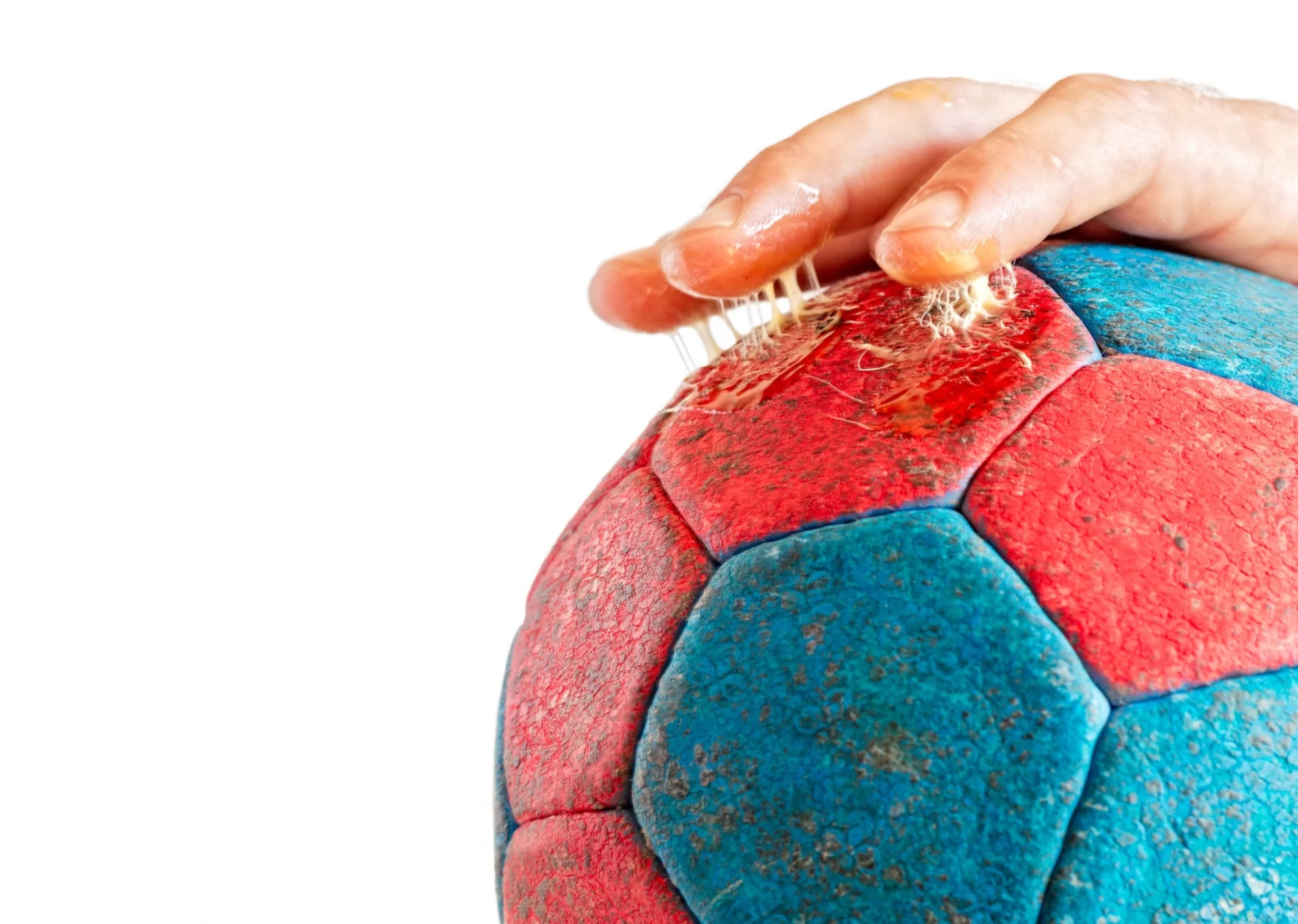 Bola de andebol azul e vermelha a ser limpa com escova