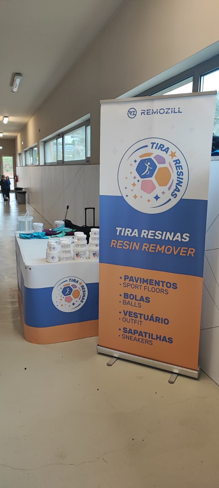 Expositor com produtos Tira Resinas e painel com indicações do produto para pavimentos, bolas, vestuário e sapatilhas