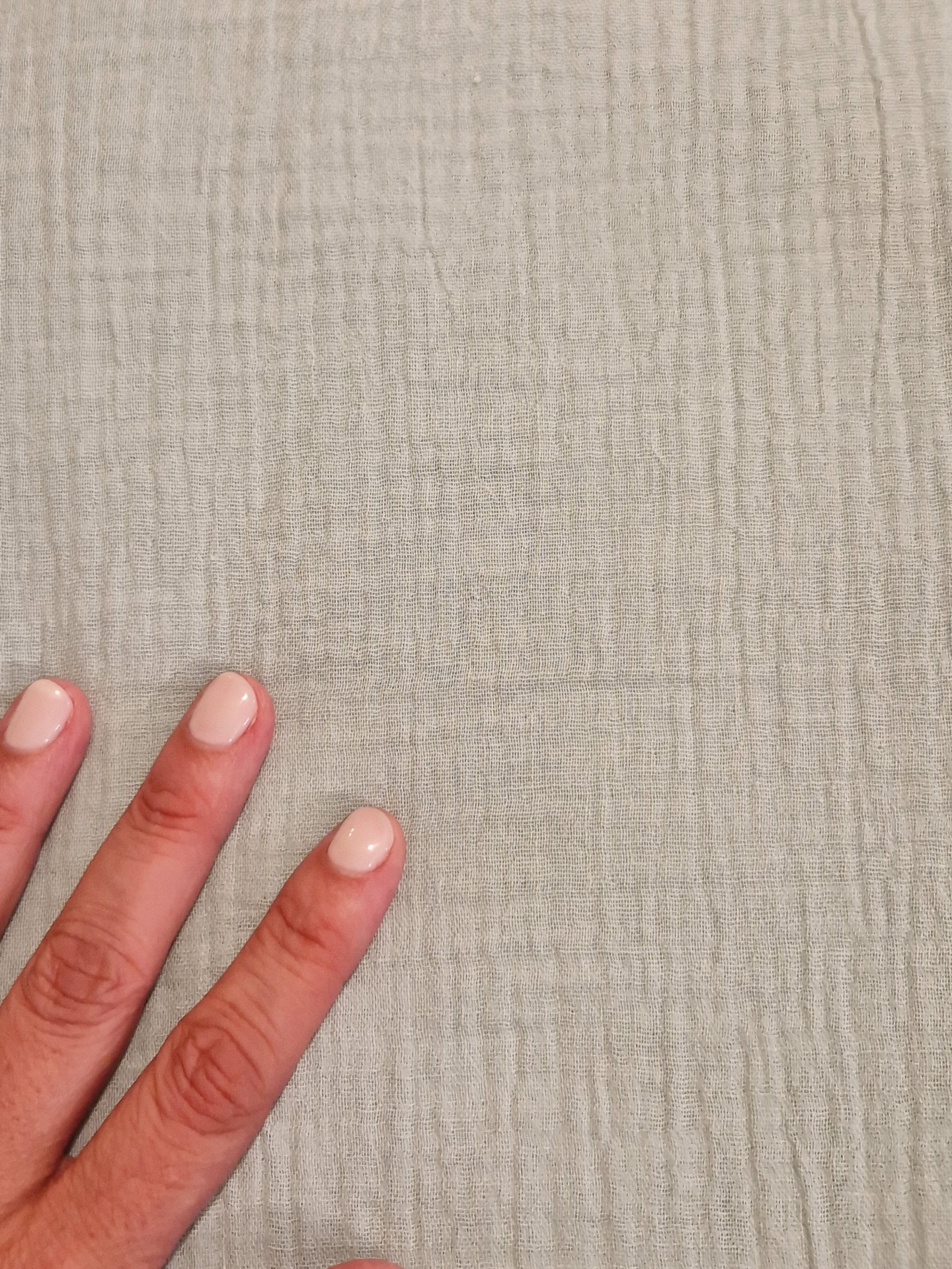 Musseline verde menta Mão com unhas creme sobre tecido beige texturizado