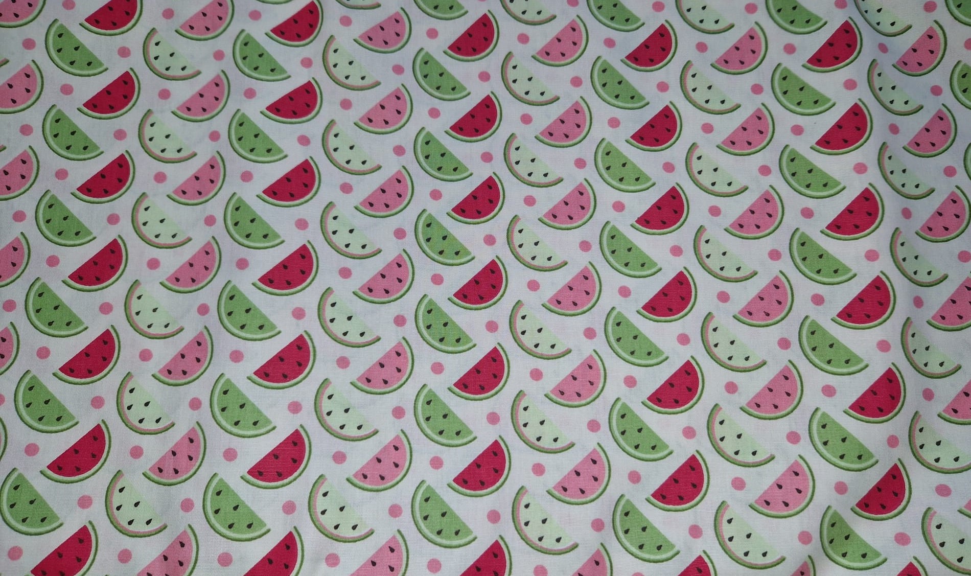 Fatias de Melancia Tecido branco com padrão colorido de fatias de melancia vermelhas, rosas e verdes.