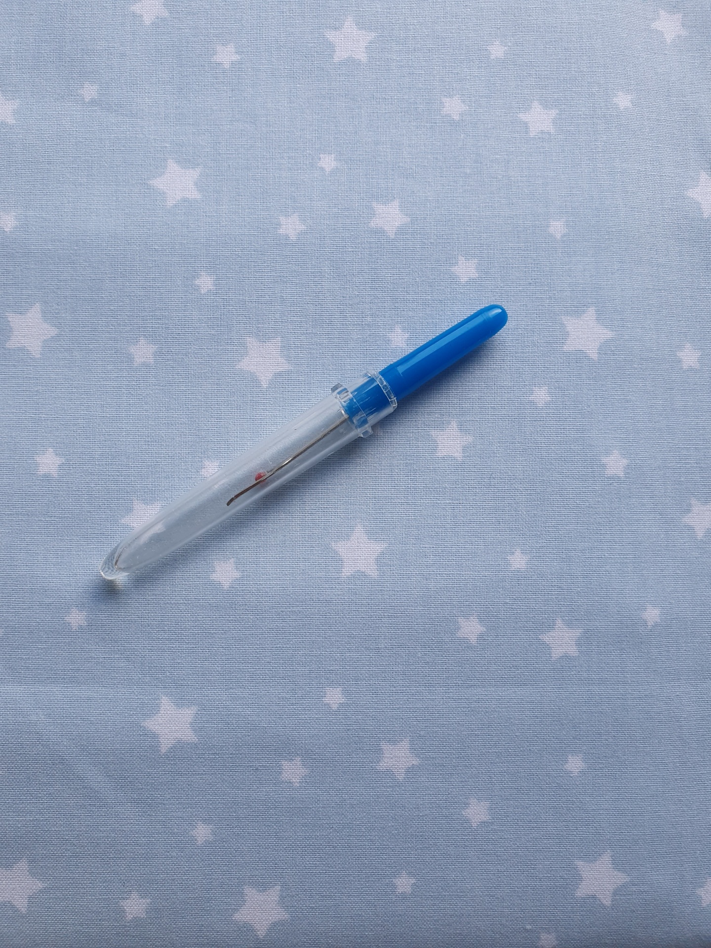 Azul estrelado Conta-gotas de plástico transparente com tampa azul sobre tecido azul claro com estrelas brancas
