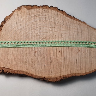 Fita verde claro bordada sobre madeira natural