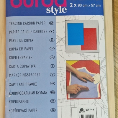 Pacote Burda Style de papel de cópia carbono em azul e vermelho sobre mesa de madeira