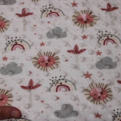 Tecido branco acolchoado com padrão infantil de leões, arco-íris, nuvens e estrelas.