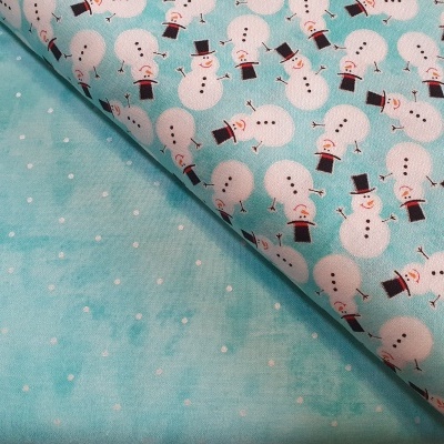 Tecido com padrão de bonecos de neve e tecido azul claro com pontos brancos