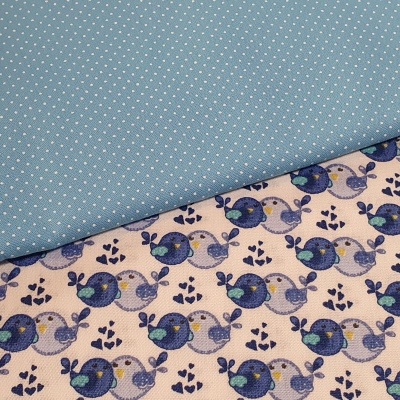 Dois tecidos, um azul com pontos brancos e outro creme com pássaros azuis e lilases.