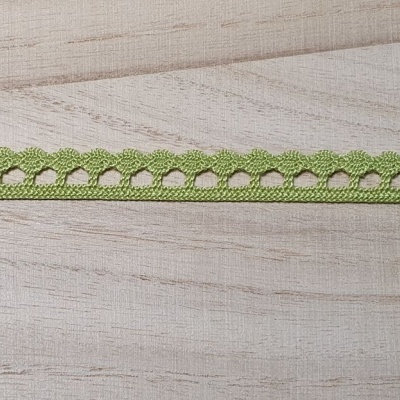 Fita decorativa verde com corações em tecido sobre madeira clara