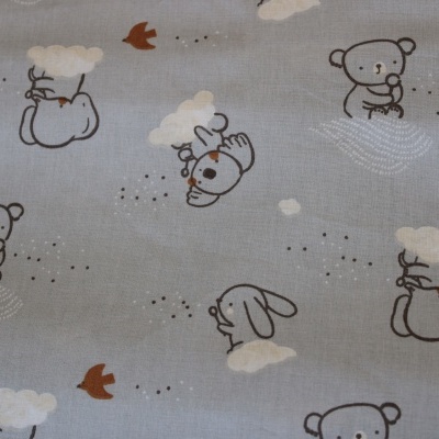 tecido azul claro com padrão de ursos, coelhos e nuvens desenhados