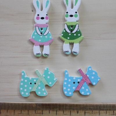 Botões de madeira em formas de coelho e cão com padrões coloridos e régua ao lado