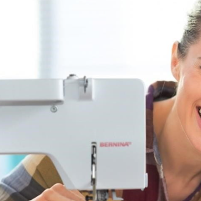 Máquina de costura branca BERNINA com mulher sorridente ao lado