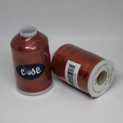 Dois rolos de linha metálica cobre sobre superfície branca