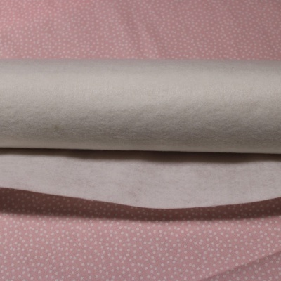 Rolo de tecido branco sobre fundo cor-de-rosa com pontos brancos