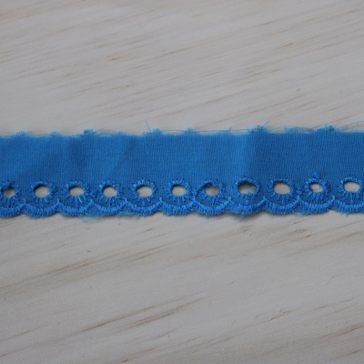 Fita azul decorativa com recortes circulares sobre superfície de madeira clara