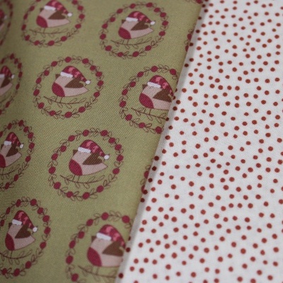 Dois tecidos, um verde com bolos em círculos e outro branco com pontos vermelhos.