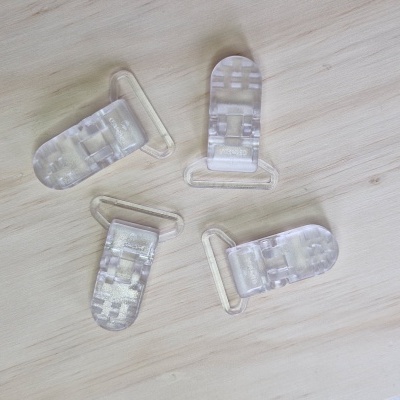 Presilhas transparentes de plástico sobre madeira clara