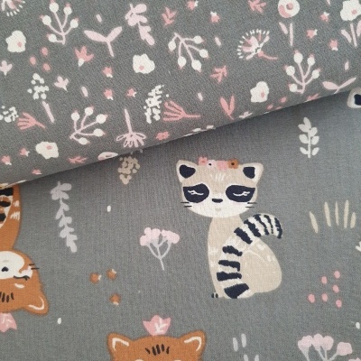 Tecido infantil com padrões de raposas, guaxinins e flores em tons suaves sobre fundo cinza.