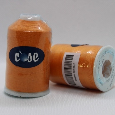 Dois carretéis de linha de costura laranja com etiquetas e código de barras