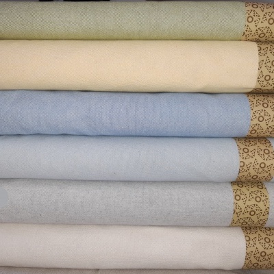 Tecidos dobrados em várias cores suaves com fitas decorativas enroladas