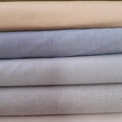 Pilha de tecidos em cores pastel uniformes e textura lisa