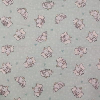 Tecido azul claro com elefantes cor-de-rosa desenhados e pequenos corações verdes.